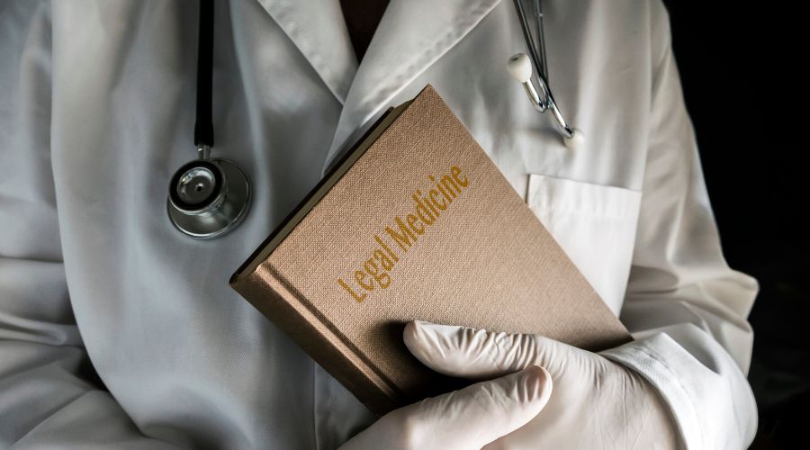 medico con in mano un testo di medicina legale