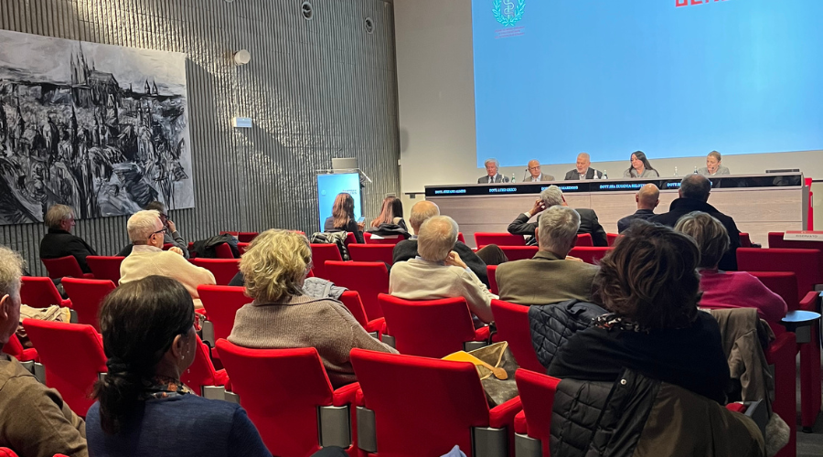 scatto della sala con pubblico di spalle e tavolo dei relatori dell'assemblea di dicembre 2025