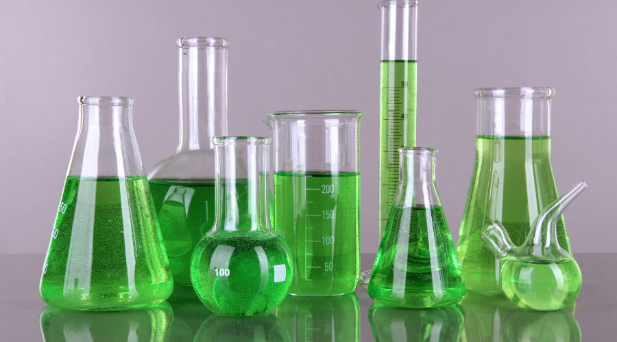 insieme di ampolle e provette per laboratorio contenenti liquido verde